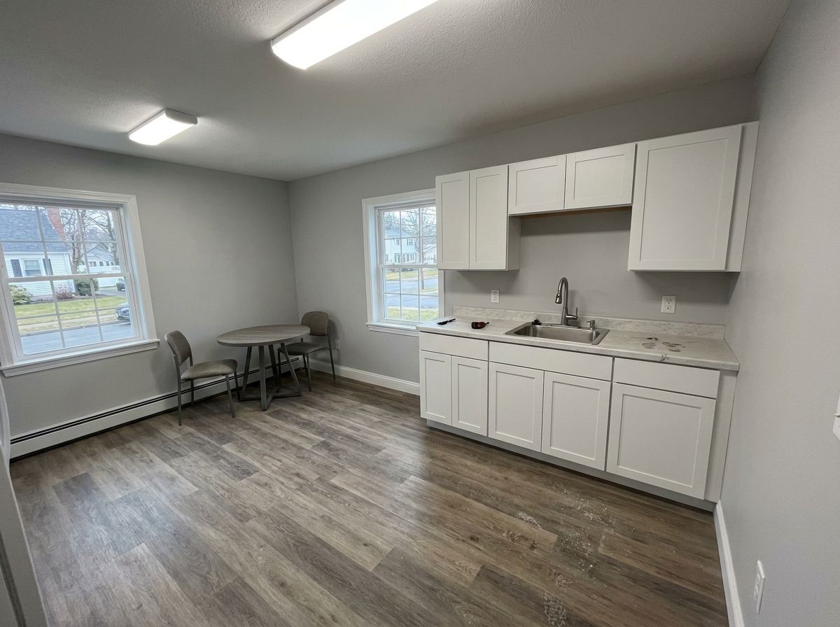 Refreshed office break room with new cabinets and vinyl plank floor