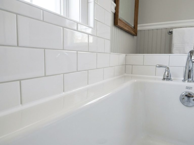 Completed tub caulking in Bellingham, MA — clean new silicone joint where subway tile meets the tub