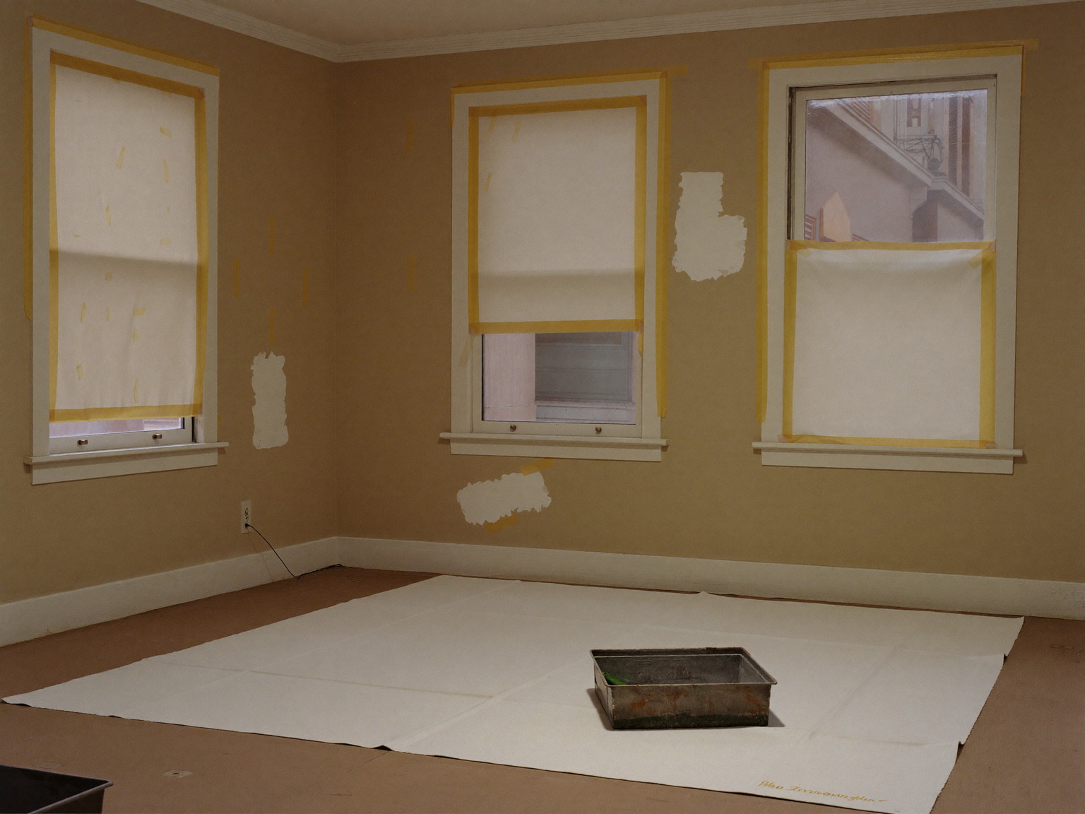 Prep day in a Federal-era Boston parlor, tidy and completely unoccupied: a large canvas drop cloth over the floor, windows masked for painting, patched plaster spots sanded smooth, one plain metal paint tray on the cloth