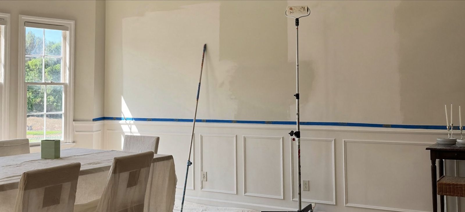 Roller pole and protected furniture in a dining room during interior painting