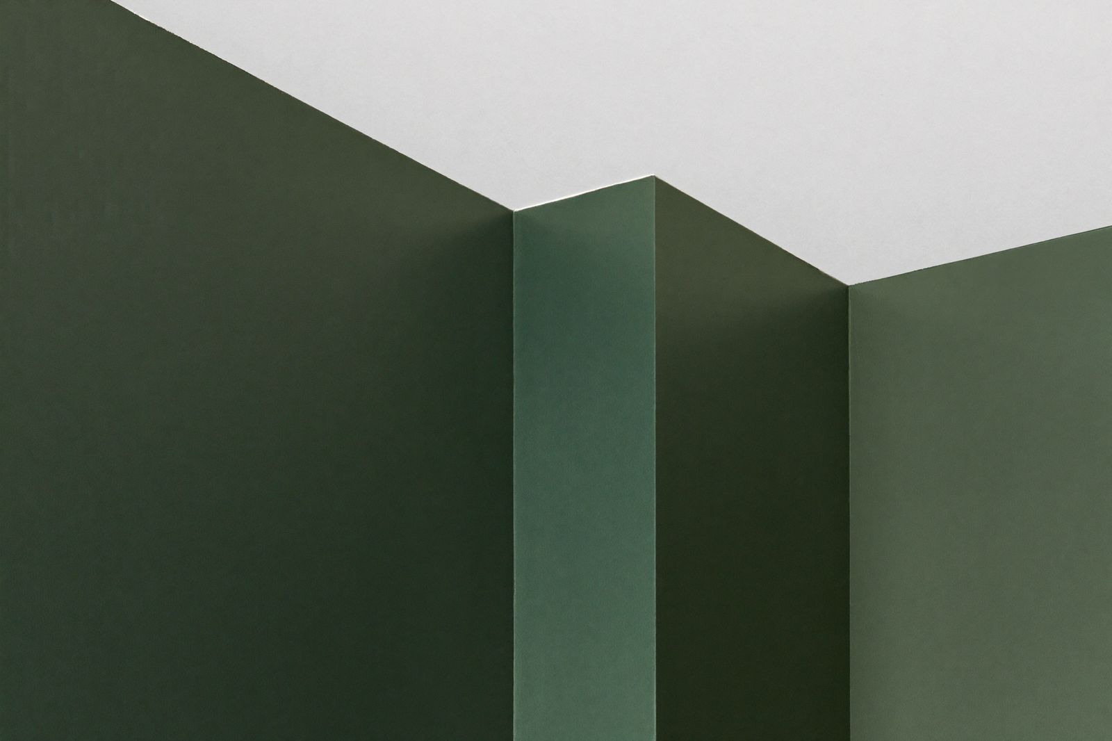 Crisp paint line where deep green walls meet a bright white ceiling