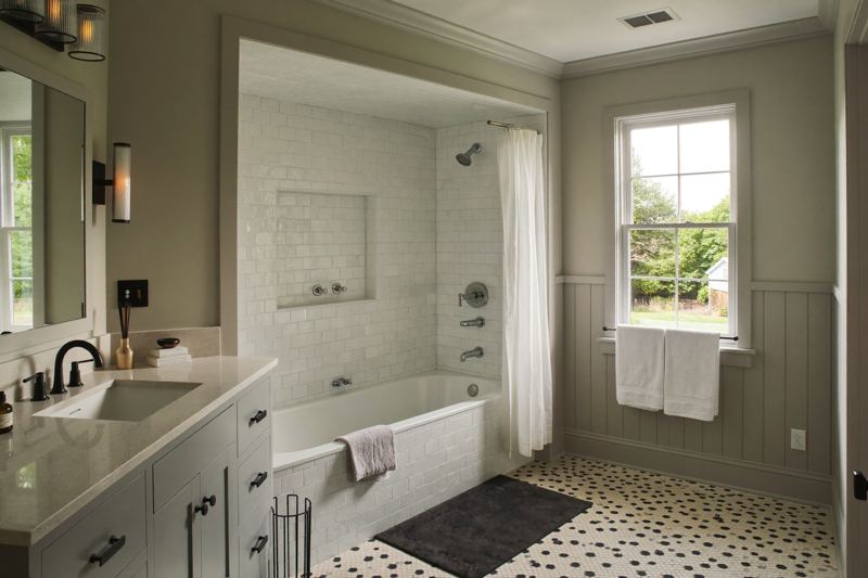 Remodeled family bathroom with tub, subway tile surround, and basketweave tile floor
