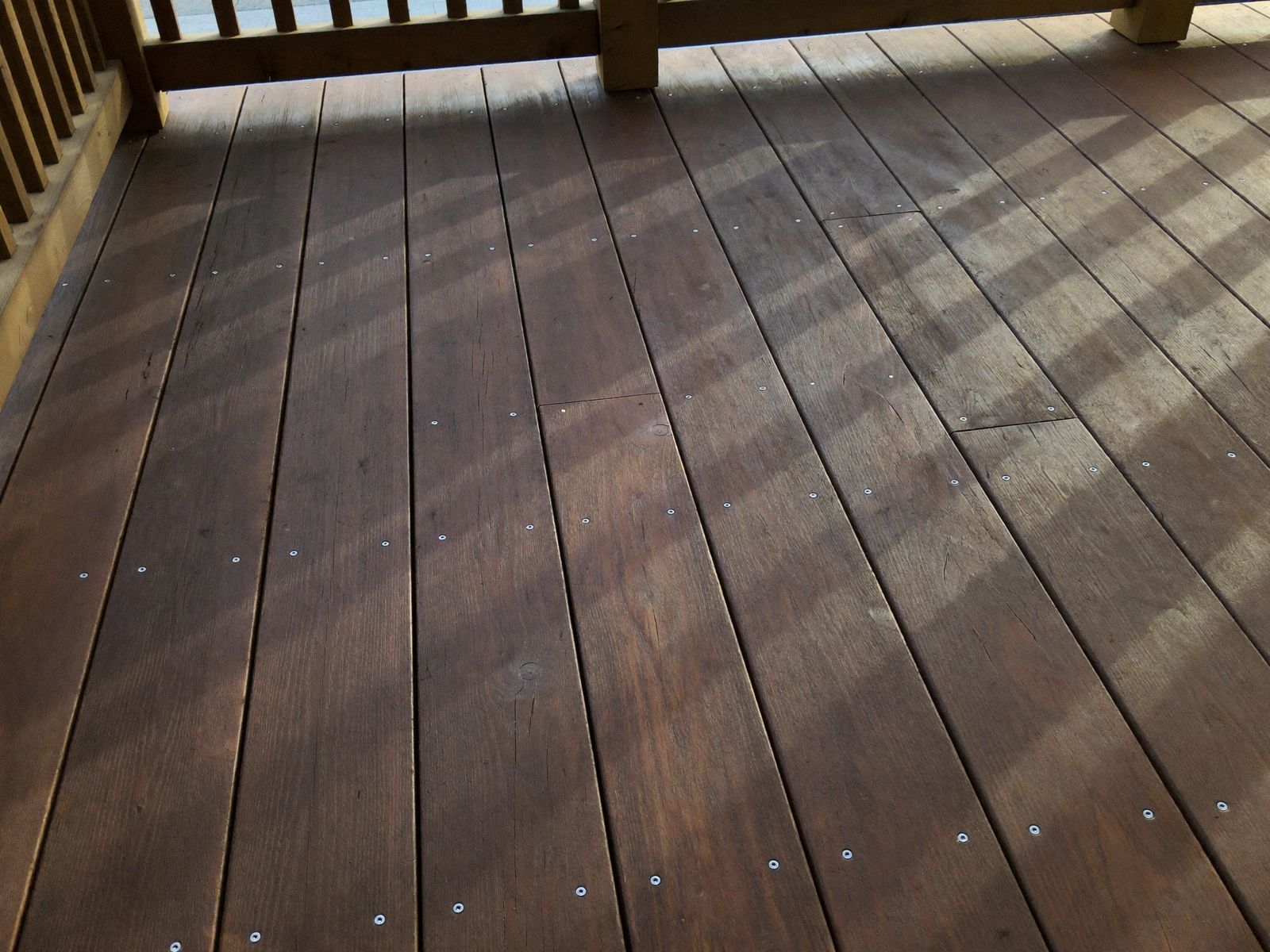 Deck board and railing joinery detail with fresh stain