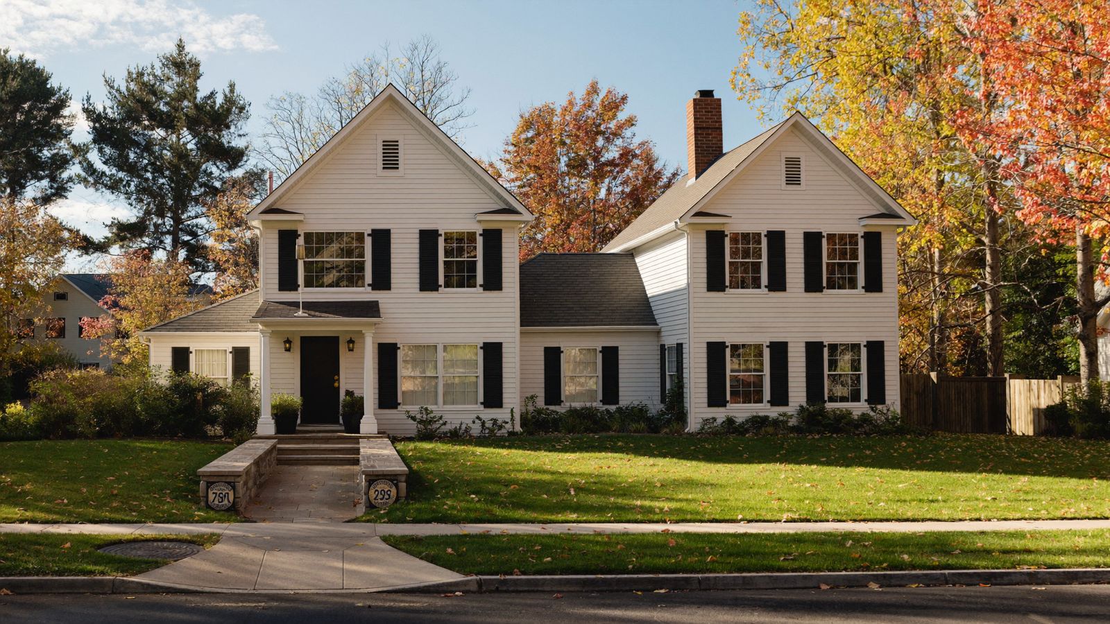 Cape-style home on a tree-lined street in Bellingham, MA in autumn