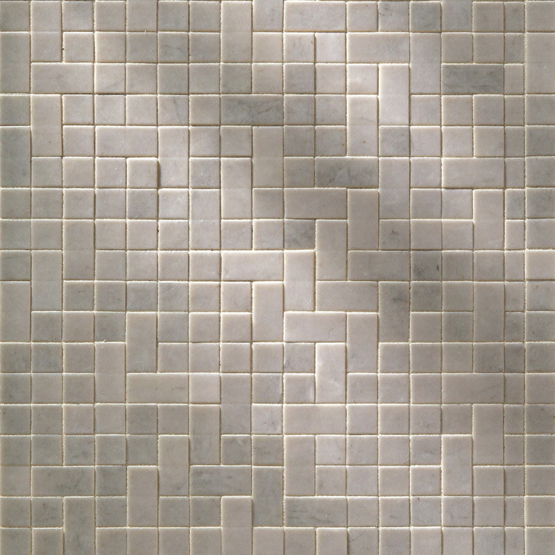 Close detail of honed carrara marble basketweave mosaic tile with soft grey veining and fine ivory grout lines, raking light across the surface