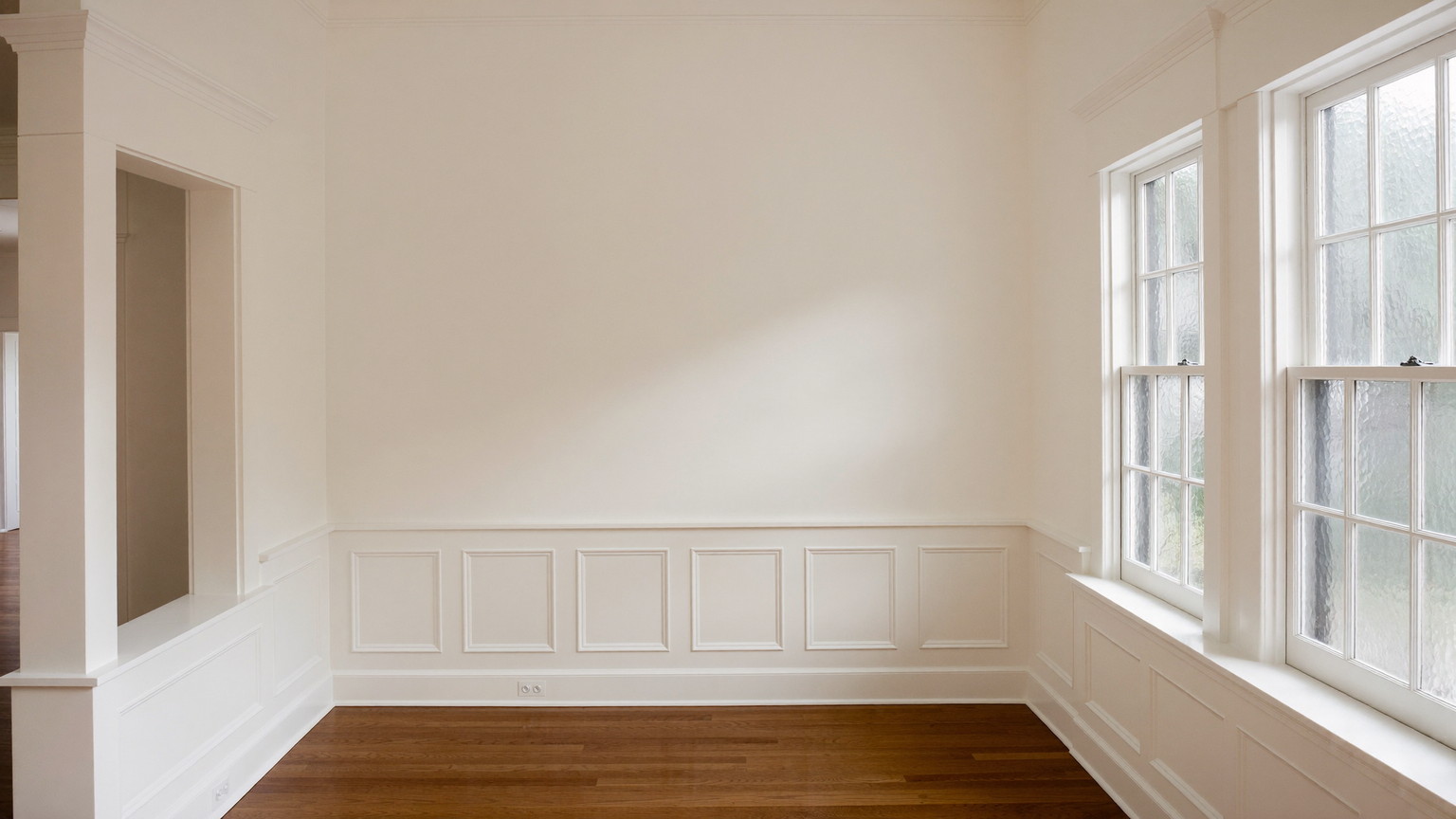 Editorial photograph of a freshly repainted parlor in an older Cambridge Massachusetts home: warm white walls over restored smooth plaster, bright white glossy
