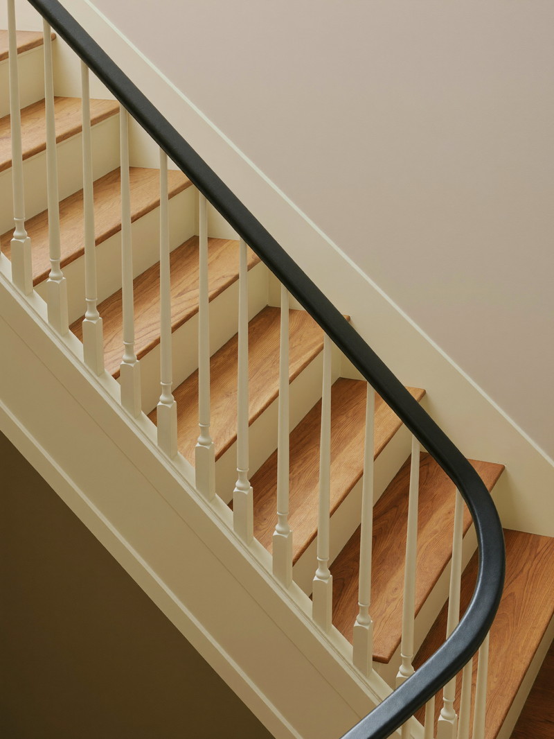 Down to the finished lower level of a Framingham colonial: a refinished stair with soft cream risers and stringers, warm hickory treads