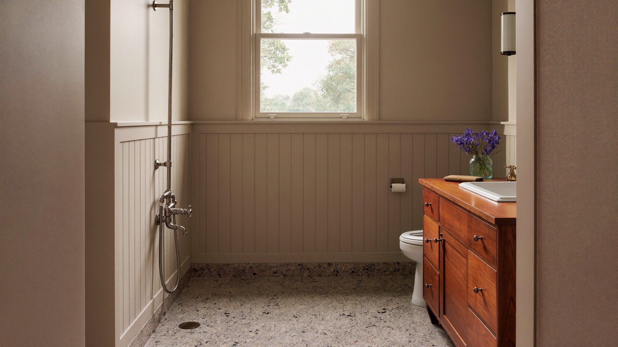 A serene renovated bathroom in an established Framingham Massachusetts colonial, photographed for a design journal: warm taupe painted paneling