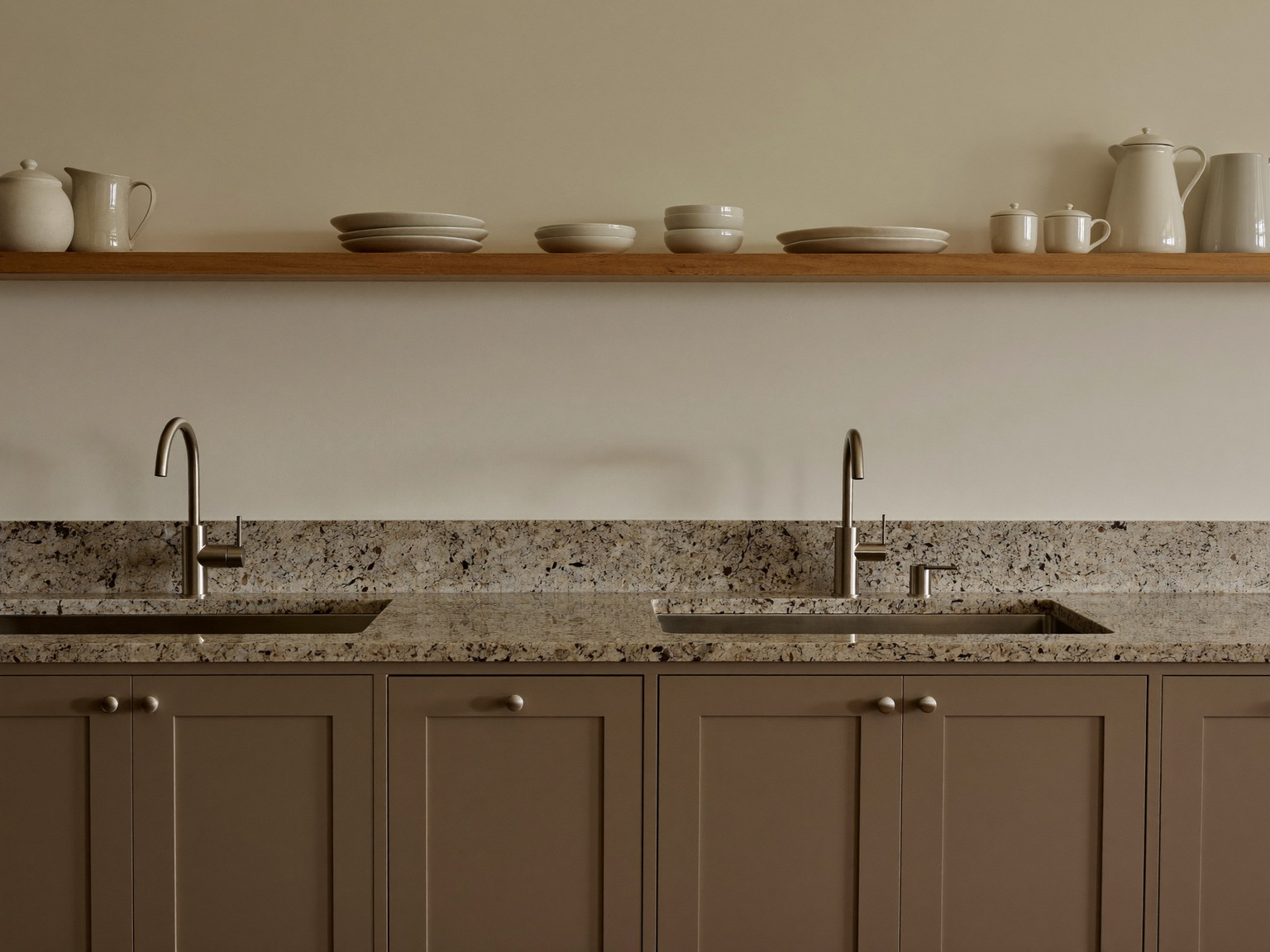Down the counter run of a renovated Framingham family kitchen: warm taupe shaker cabinetry, honed granite counters completely clear