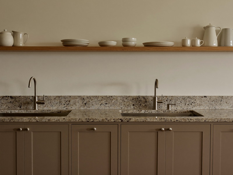 Down the counter run of a renovated Framingham family kitchen: warm taupe shaker cabinetry, honed granite counters completely clear