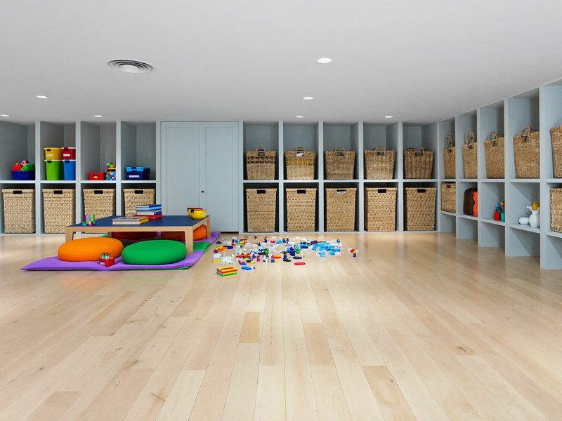 Colorful finished lower-level play space with blue storage cubbies, woven baskets, and a low play table