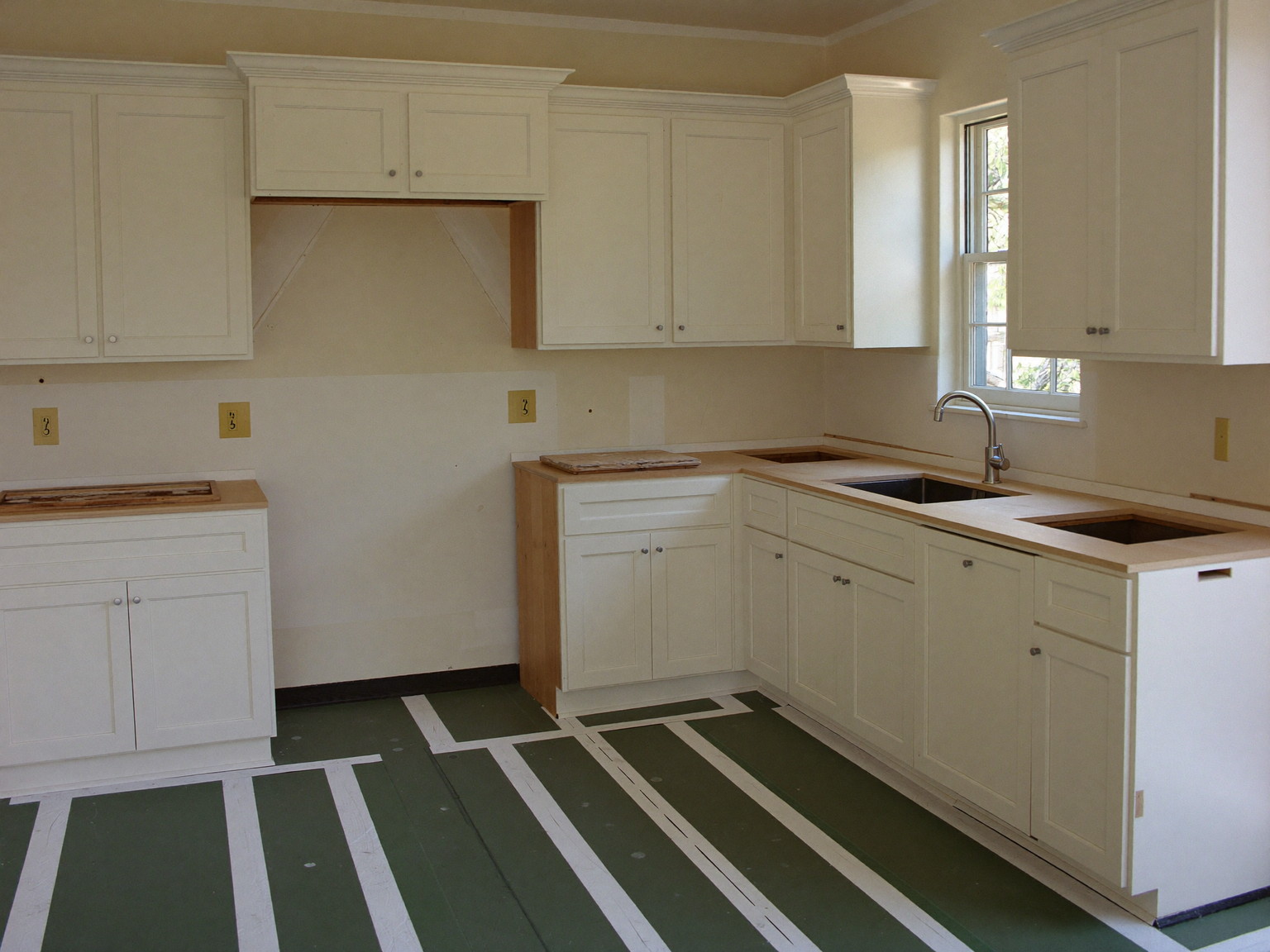 Kitchen renovation in progress: new cabinets set, counters pending, floors protected