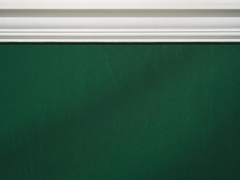 Close-up of a crisp hand-cut paint line where a deep oxblood wall meets bright white crown molding