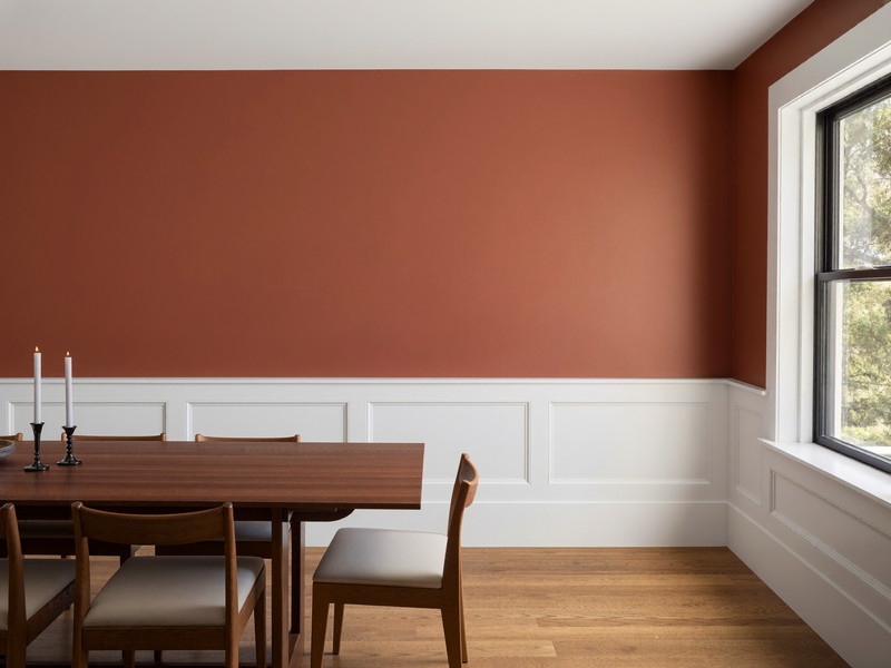 Dining room with deep ink-blue walls above crisp white painted wainscoting and a warm oak floor