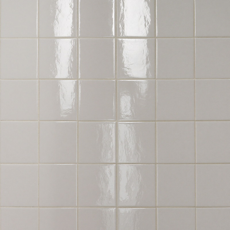 Plain glossy white square ceramic tiles laid in a perfect straight grid with soft ivory grout lines, every tile identical smooth and flat, gentle window