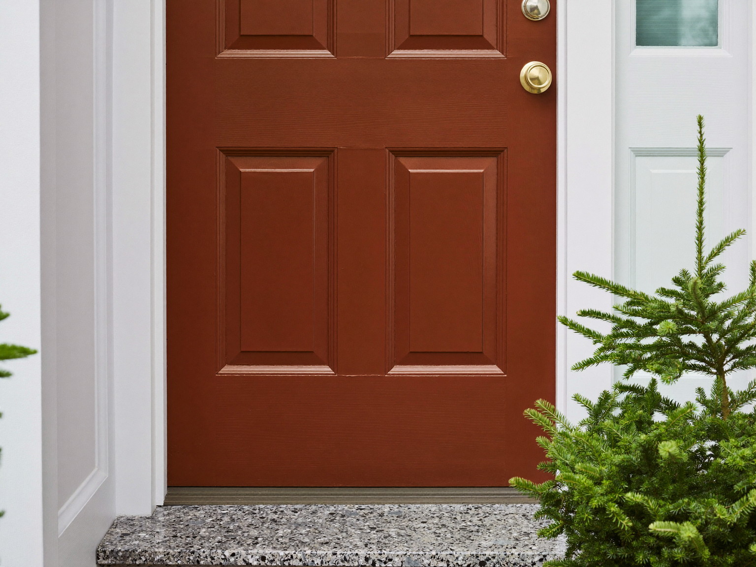 A refreshed New England front entry: paneled front door repainted in deep russet satin enamel, repaired bright white casing, one plain round brass knob with
