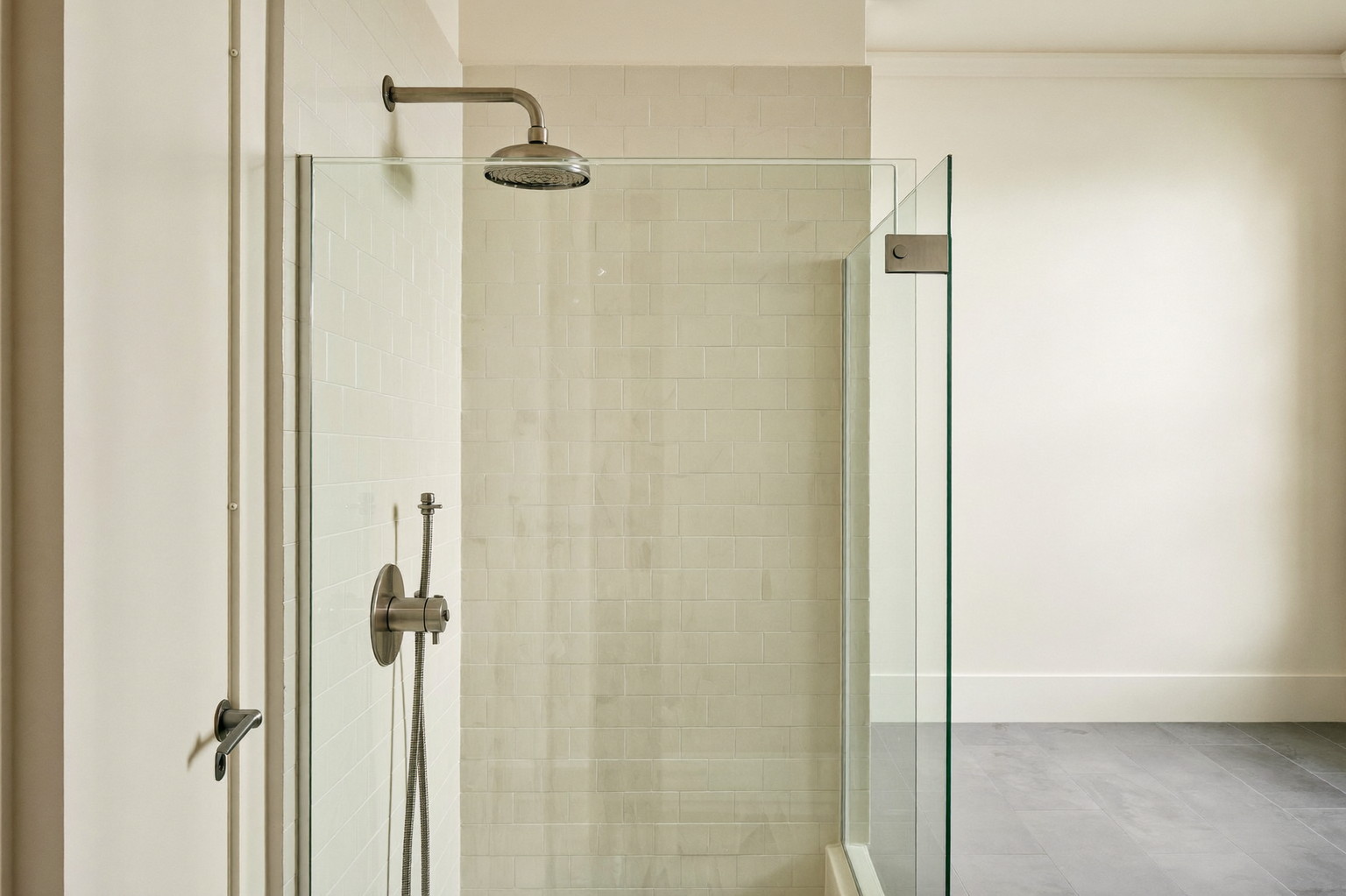 Looking into a glass-paneled walk-in shower in a renovated Lexington colonial bathroom: ivory subway tile, brushed pewter rain head and controls, honed slate-gray floor