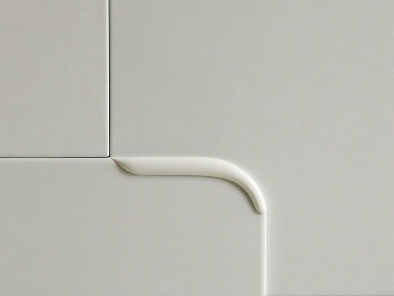 A clean even bead of fresh white caulk sealing the tub-to-tile joint, tooled smooth, soft window light