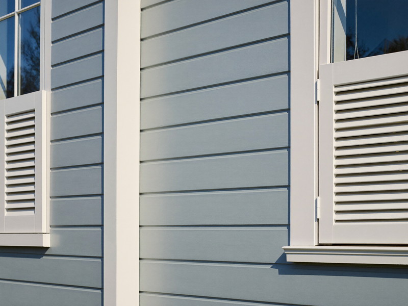 Detail of freshly repainted soft blue-gray clapboard siding on a comfortable Medway colonial: narrow horizontal clapboards, a crisp white corner board,