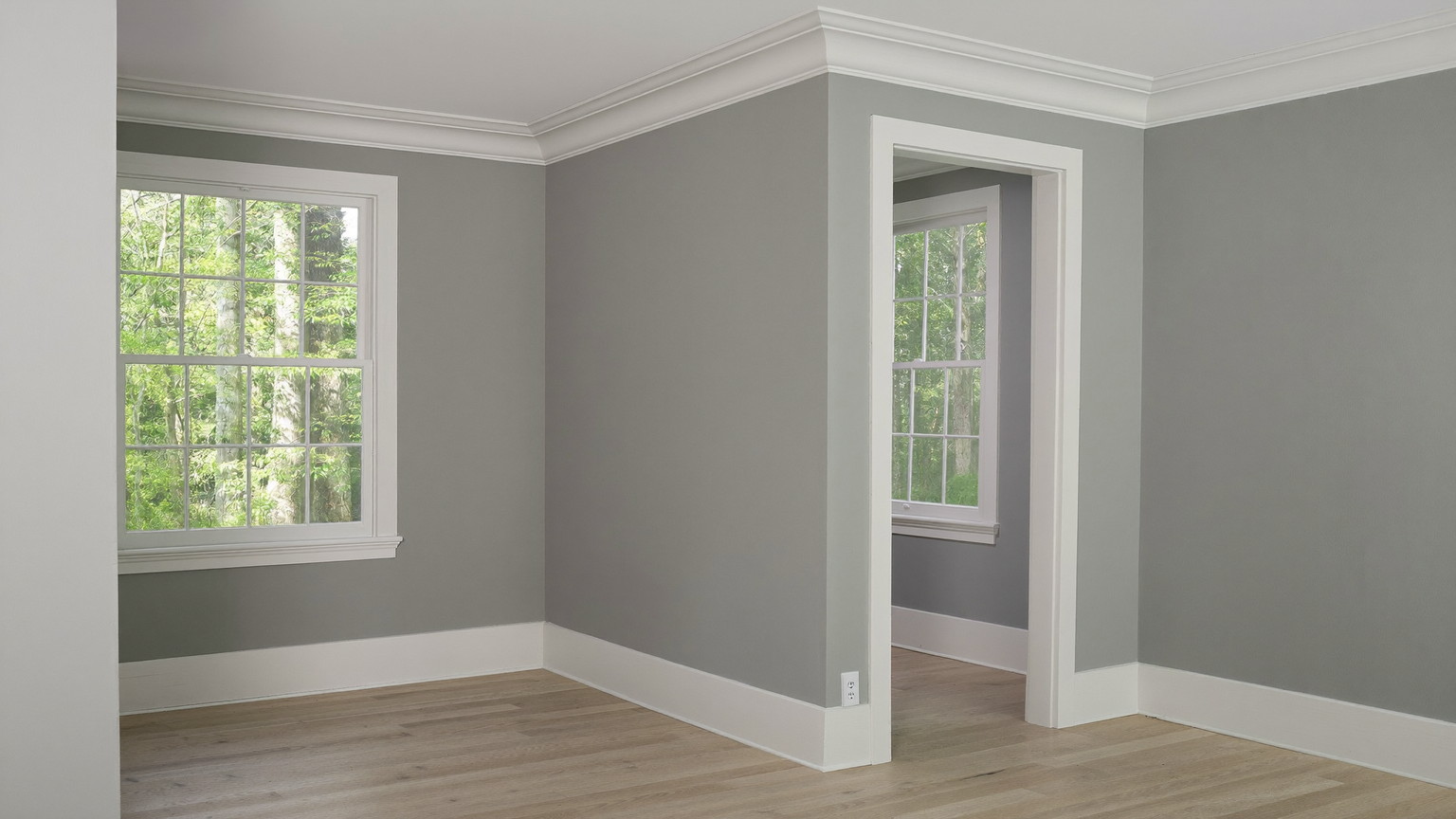 A freshly repainted family room in a comfortable Medway Massachusetts colonial: soft blue-gray walls, bright white glossy trim and crown molding, restored