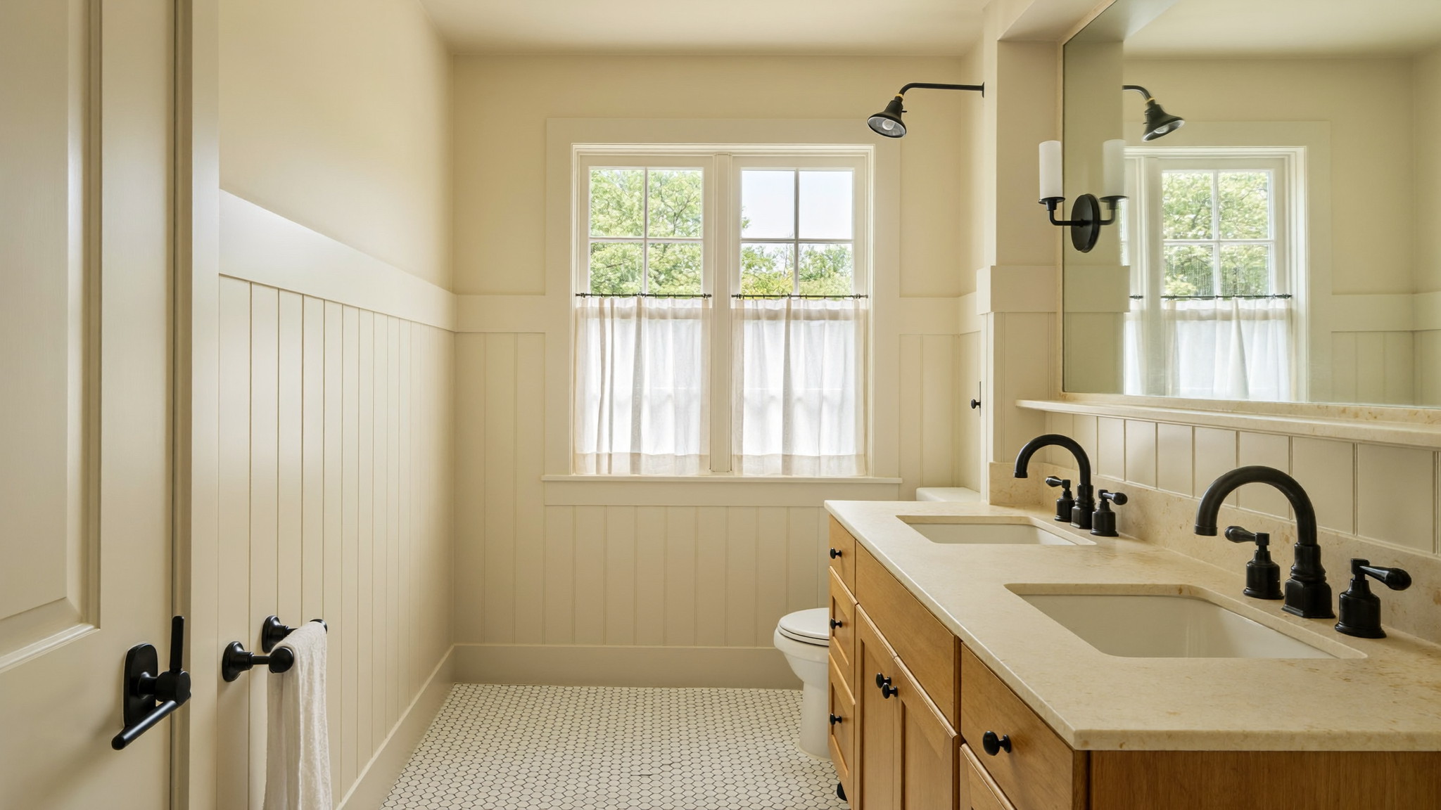 A bright renovated bathroom in a well-kept Millis Massachusetts colonial, photographed like a magazine feature: cream painted beadboard walls, matte black