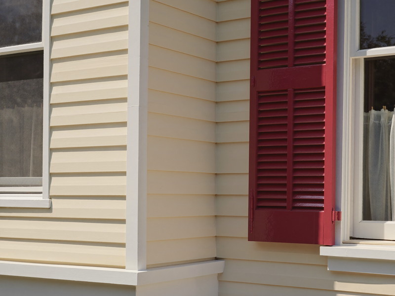 Detail of freshly repainted cream clapboard siding on a well-kept Millis colonial: narrow horizontal clapboards, a crisp white corner board, the edge of a