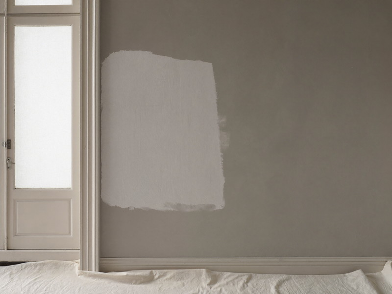 Drywall patch primed and feathered in beside door trim — illustrative imagery