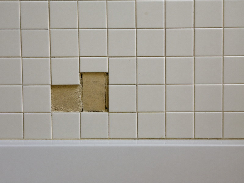 Bathroom floor tile repair finished flush with clean new grout lines — illustrative imagery