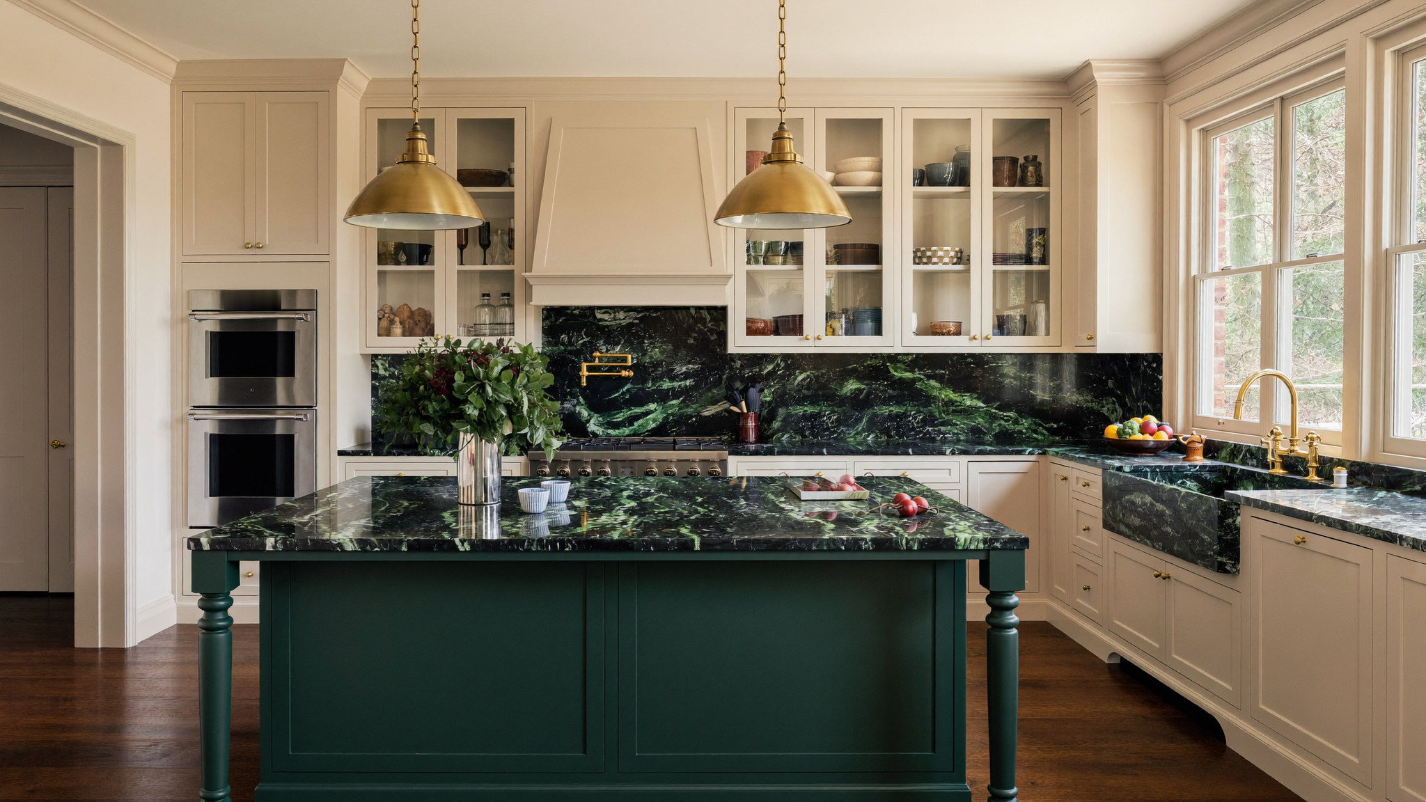 Remodeled Newton kitchen with a forest-green island, cream perimeter cabinets, brass library lights, and tall original windows