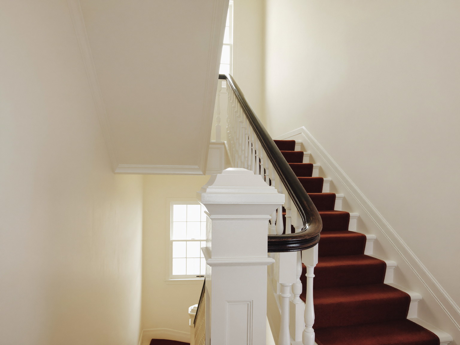 Repainted hallway and staircase with crisp white trim and soft daylight — illustrative imagery
