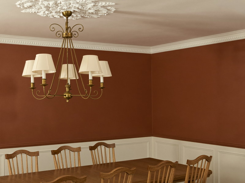 Dining room with deep ink-blue walls above crisp white painted wainscoting