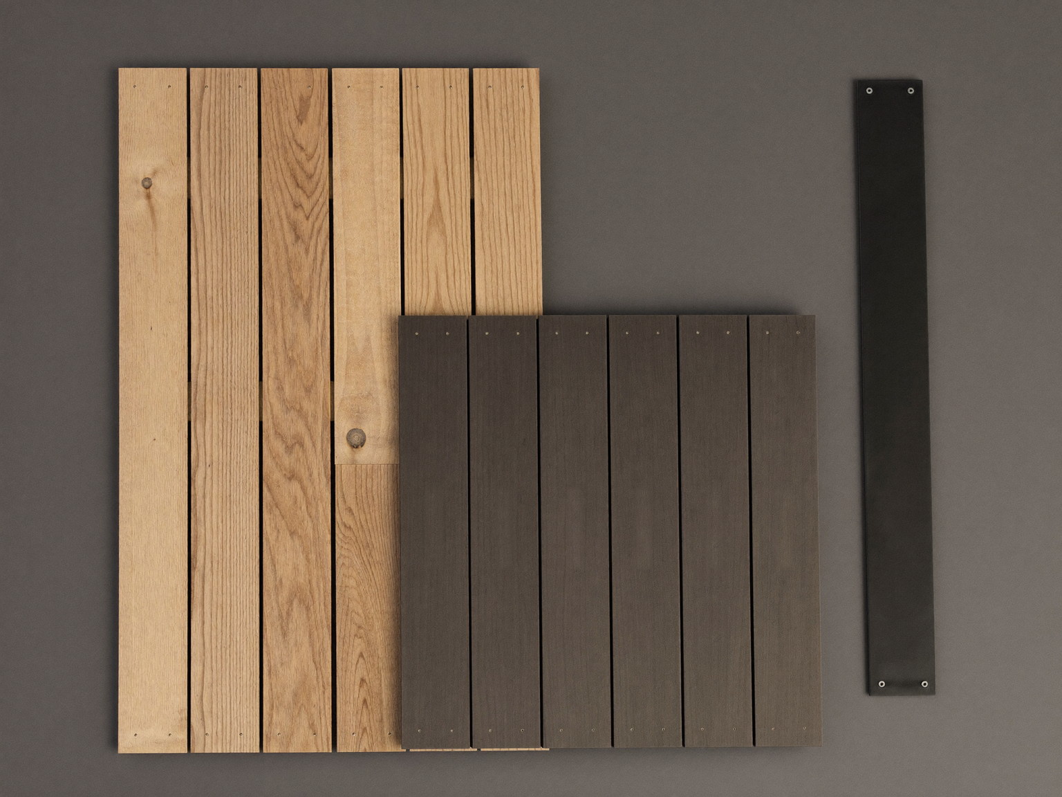 Decking materials laid out: cedar and charcoal composite boards with black railing hardware