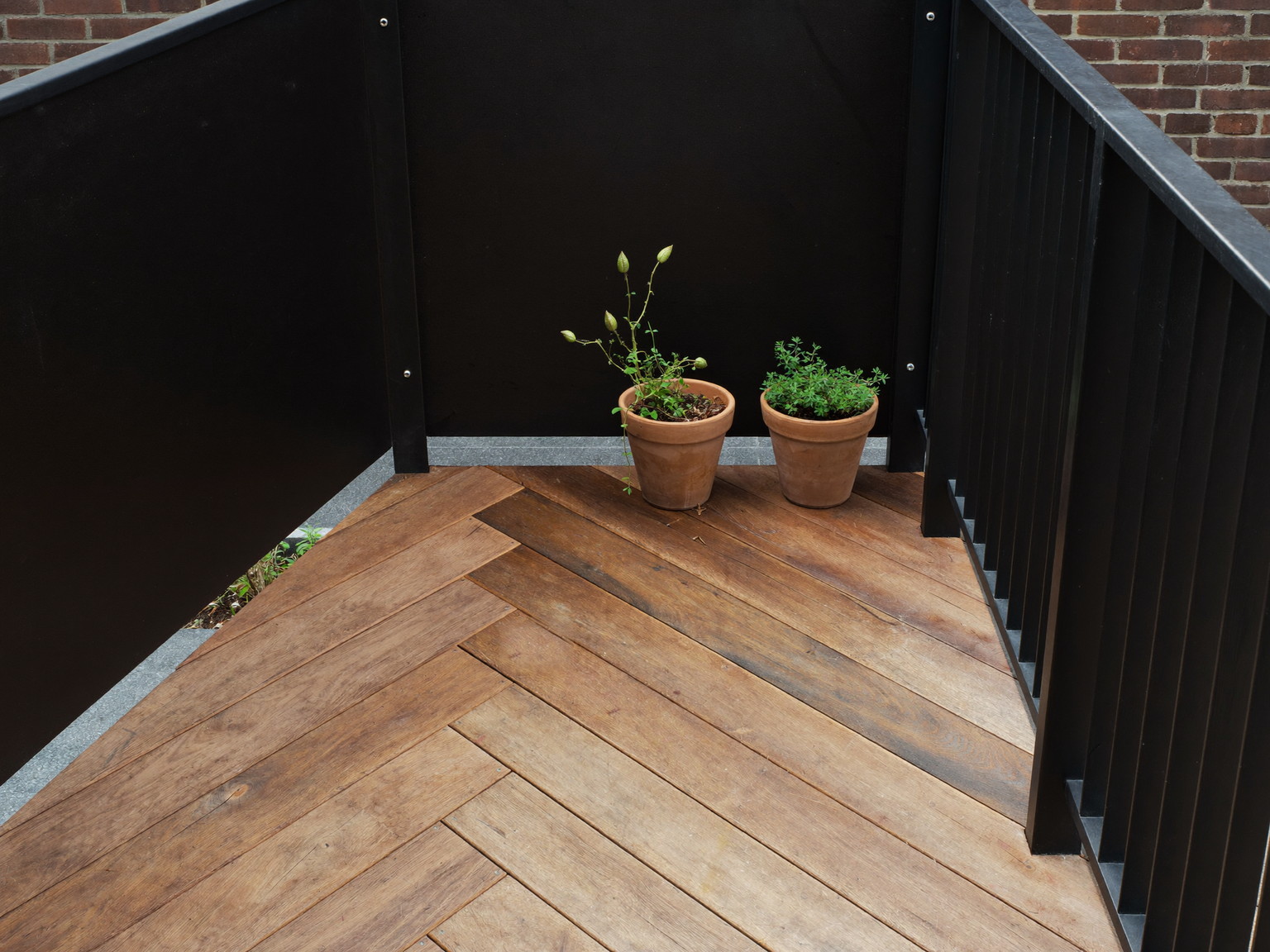 Completed deck seating corner with built-in bench, planters, and black railing at dusk — illustrative deck imagery