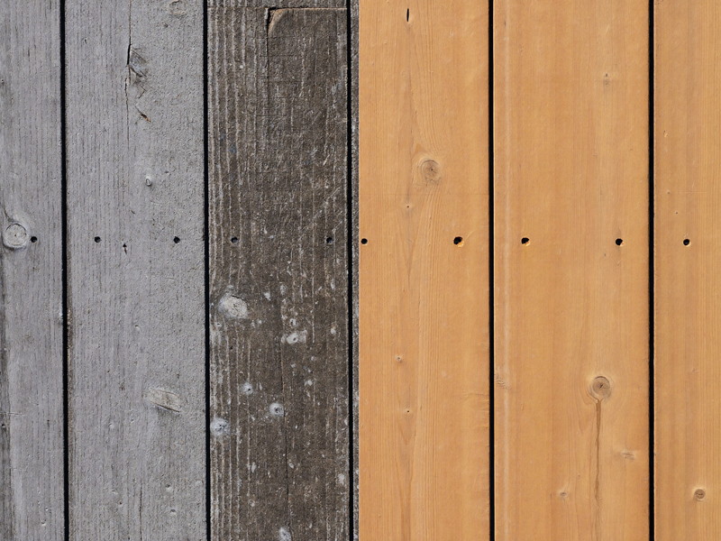 Weathered grey deck boards with surface rot beside newly installed cedar replacements