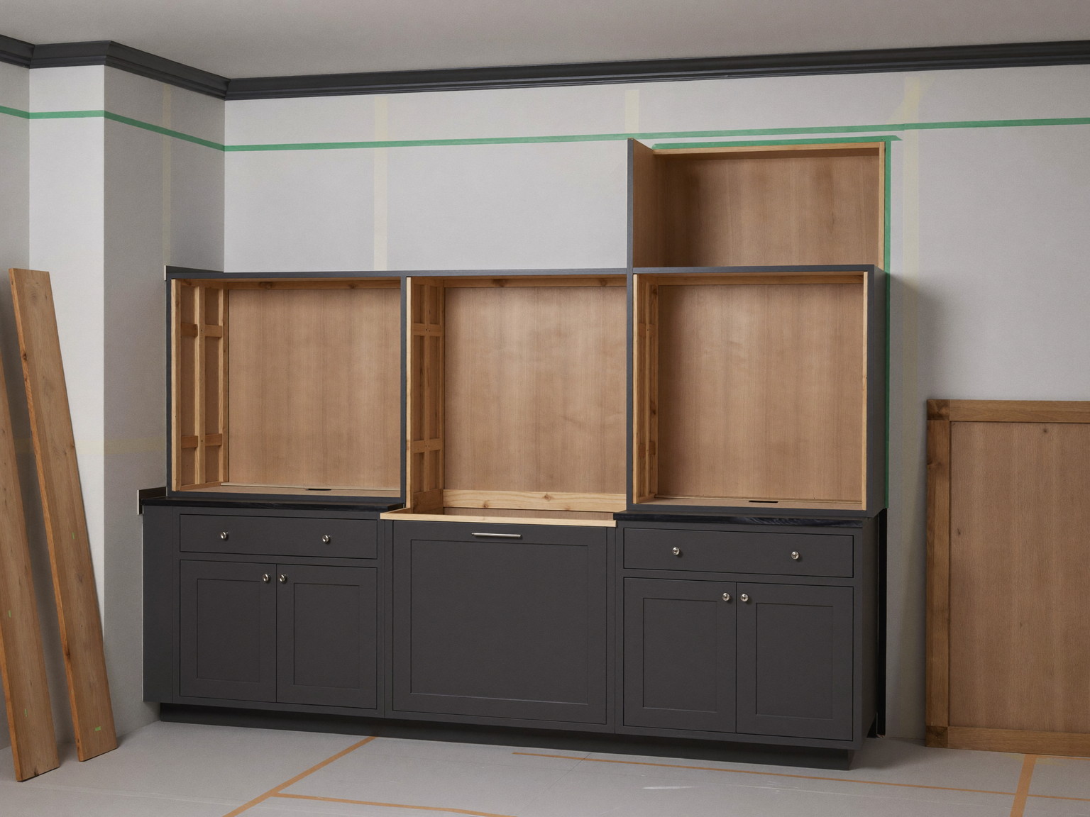 Mid-renovation kitchen with inset cabinets installed and leveled and the floors under clean protection