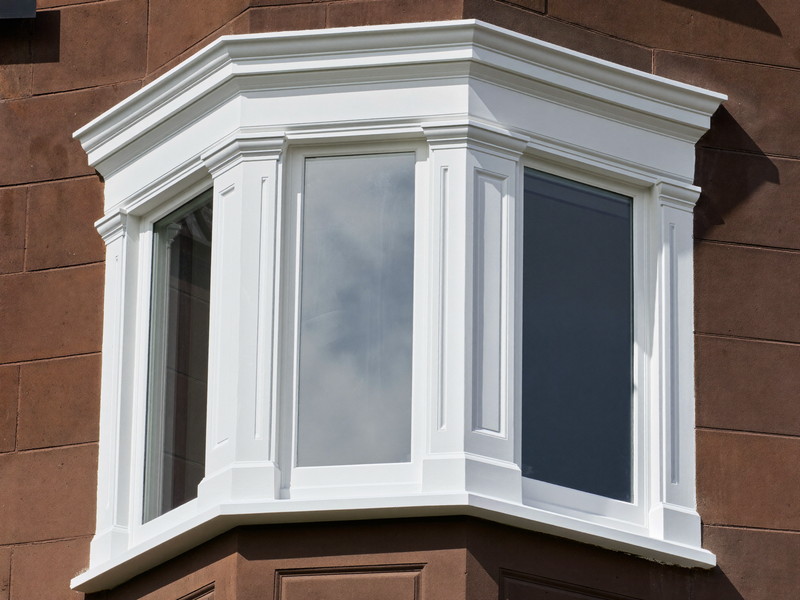 Sage clapboard siding meeting a bright white corner board and window casing